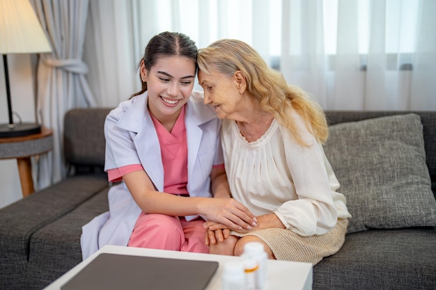 Elderly woman and nurse at home Healthcare worker girl cares about senior female person indoors