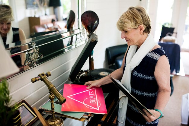 Photo an elderly woman playing a record