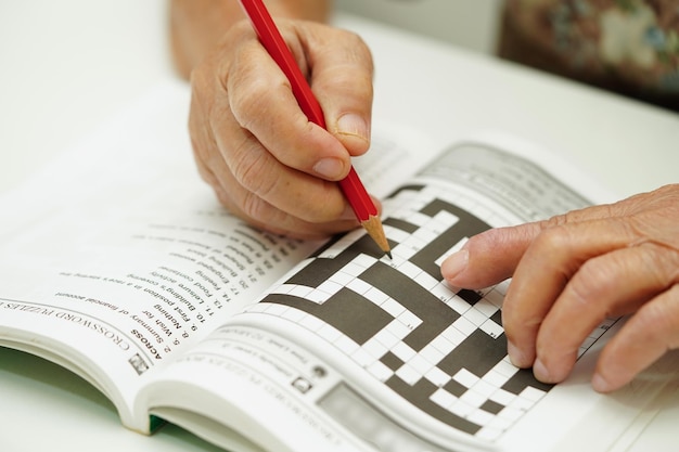 Photo elderly woman playing sudoku puzzle game for treatment dementia prevention and alzheimer disease