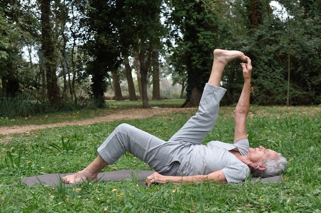 Elderly woman practicing yoga outdoors