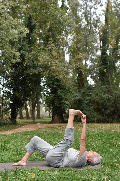 Elderly woman practicing yoga outdoors