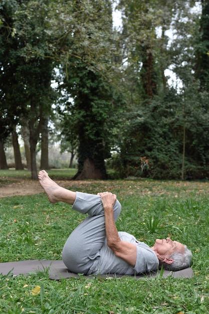 Elderly woman practicing yoga outdoors