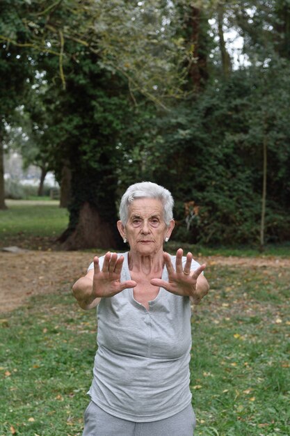 Photo elderly woman practicing yoga outdoors