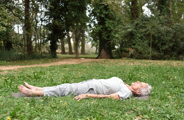 Elderly woman practicing yoga outdoors