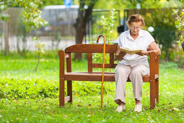 写真 年配の女性が公園のベンチに座ってリラックス