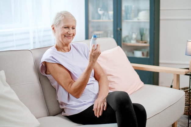 Elderly woman sitting in a yoga pose in front of an open laptop