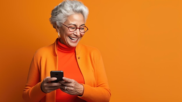 Photo an elderly woman smiling and laughing with her phone against a colored background