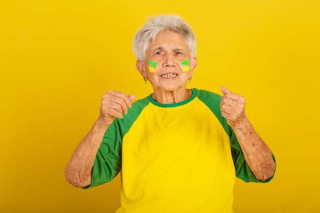 Elderly woman soccer fan from brazil cheering and vibrating