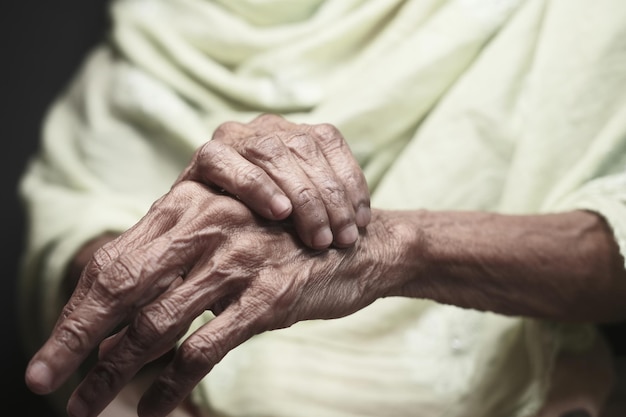 Elderly woman suffering from pain while sited