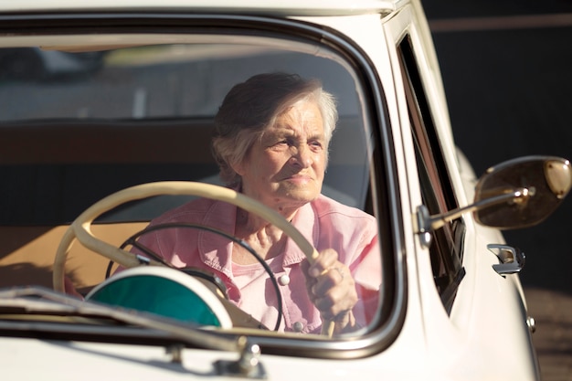 写真 白い車で旅行する年配の女性