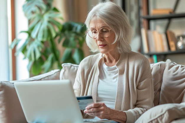 elderly woman using laptop and holding credit card