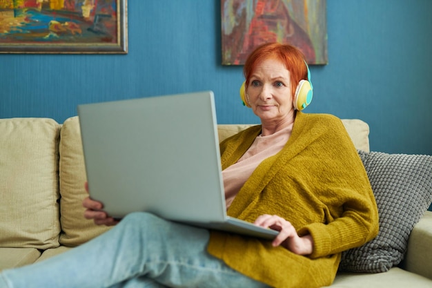 Elderly woman using laptop at home