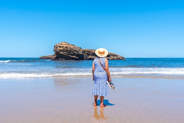 Una donna anziana in vacanza guardando il mare sulla spiaggia di biarritz lapurdi francia sud ovest località turistica