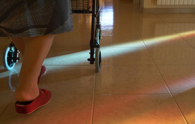 Elderly woman walks indoors with the walker