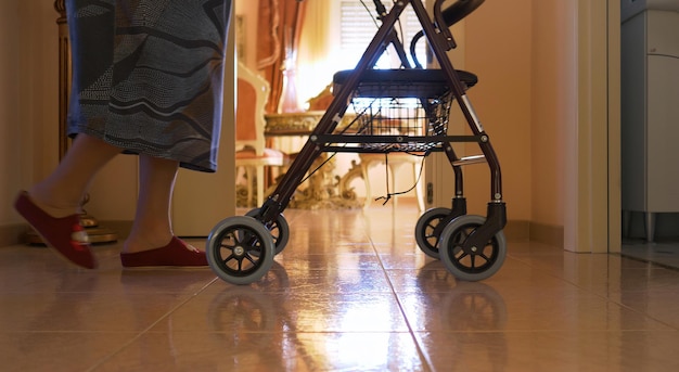 Elderly woman walks indoors with the walker