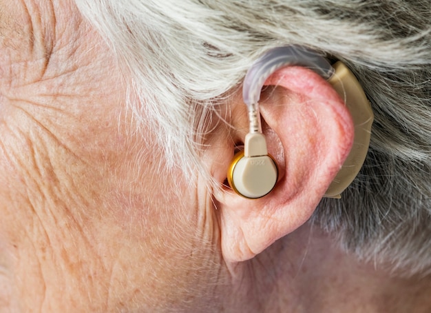Пожилая женщина с слуховым аппаратом