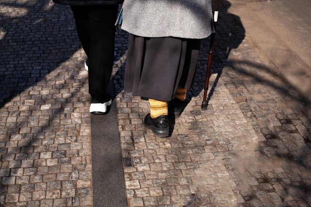 지팡이를 짚고 거리를 걷는 노인 여성