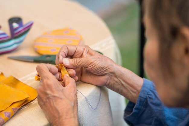 Donna anziana con caregiver nella terapia occupazionale dei mestieri dell'ago per l'alzheimer o la demenza