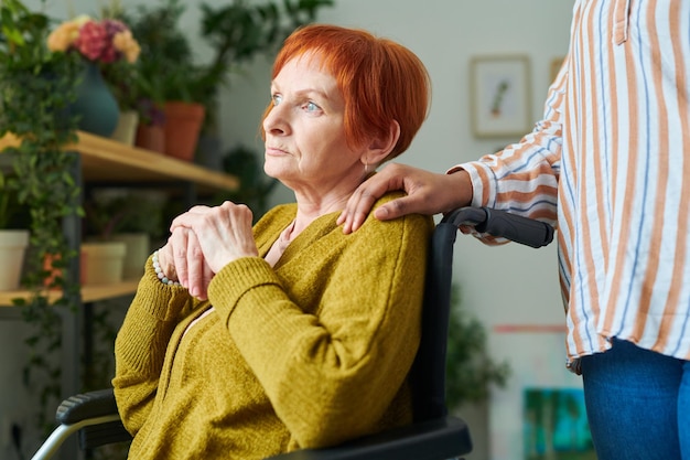 Elderly woman with disability with caregiver