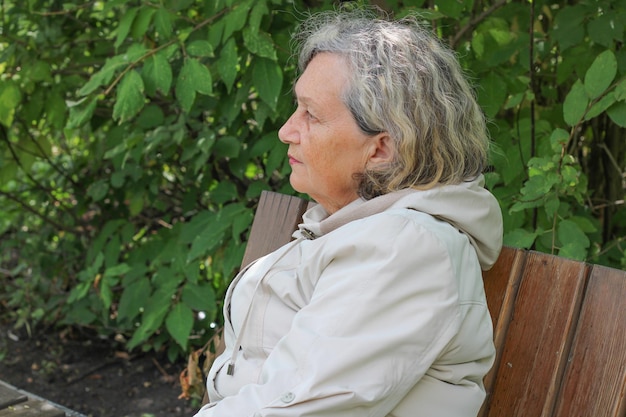 An elderly woman with gray hair is warmly dressed in cool weather Retirement age