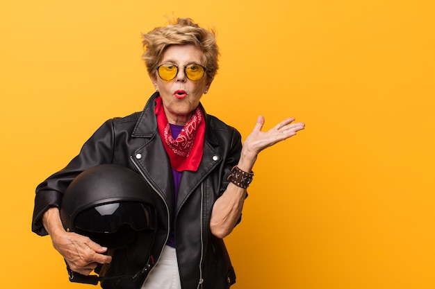 Elderly woman with lather jacket and motorcyclist helmet