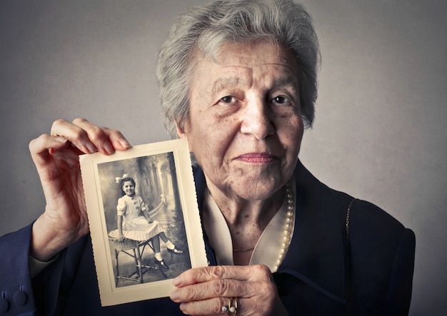 Elderly woman with a photo of herself