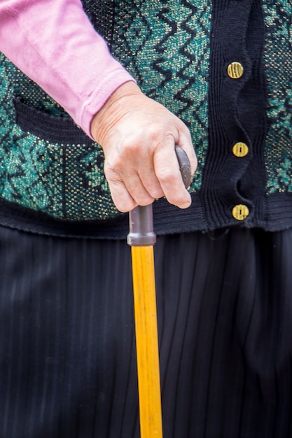 An elderly woman with stick in her hand