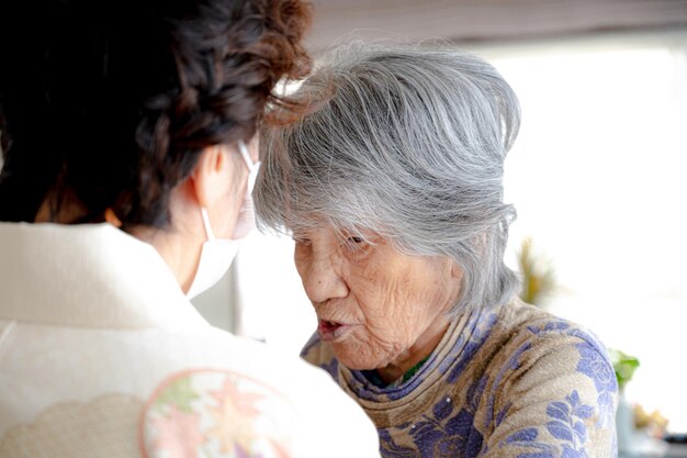 Elderly women giving dressing guidance for kimono