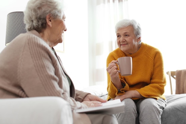 Elderly women spending time together in bedroom Senior people care