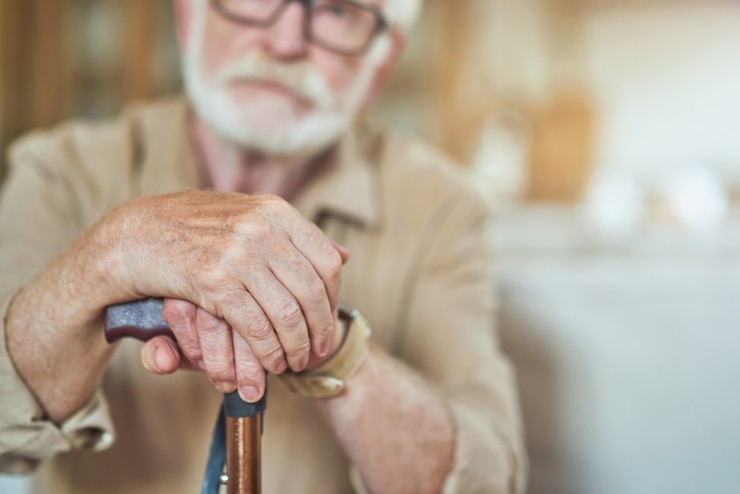 Photo elderly wrinkled male hands on walking stick
