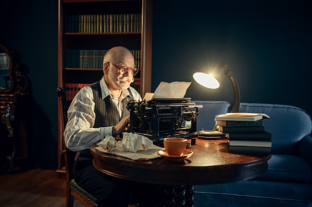 elderly writer works on vintage typewriter