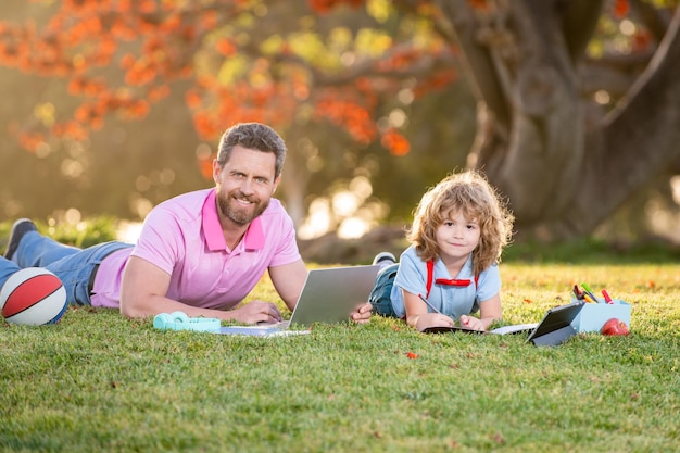 ELearning family concept Father and son with tablet computer outside in the park