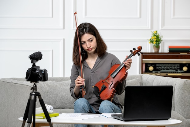 Elearning remotely at home giving violin classes young cute beautiful girl confused