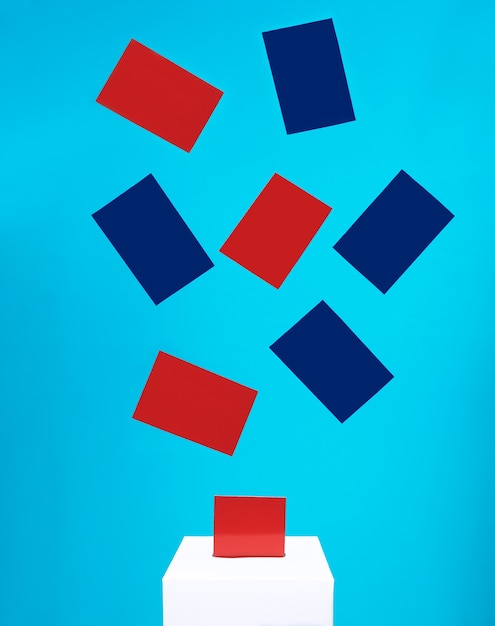 Photo election concept  blue and red cards fall into a white voting box