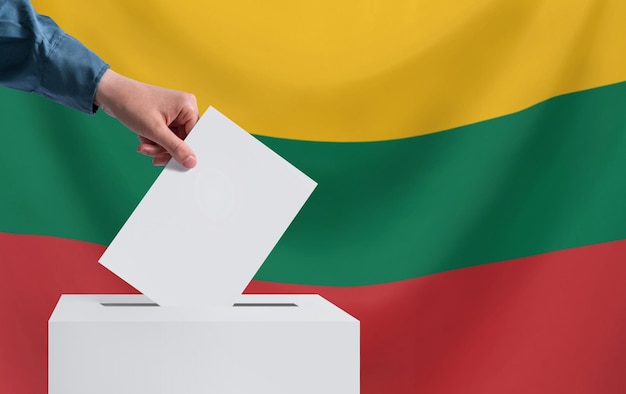 Foto elezioni in lituania una mano getta una scheda elettorale nell'urna il concetto di votazione