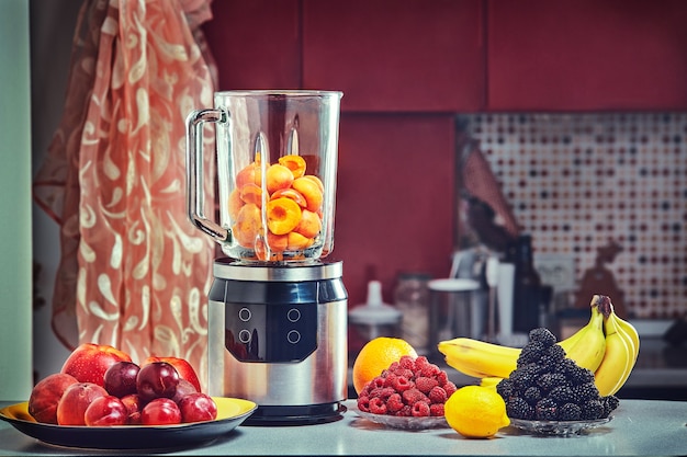 Photo the electric blender for make fruit juice or smoothie on wooden kitchen table.