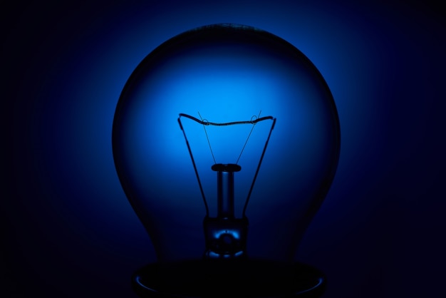 Photo electric bulb lamp with a spiral on a blue background