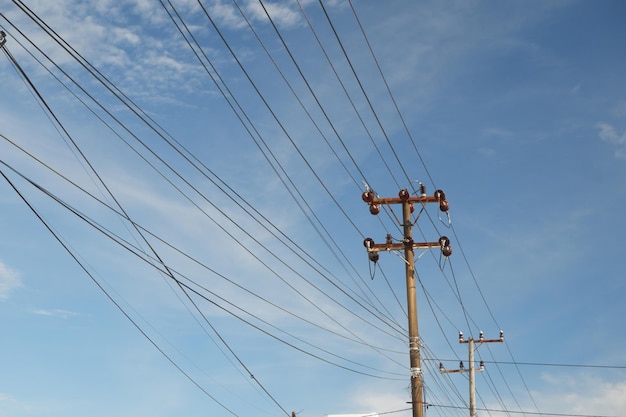 明るい青い空に照らされた電線の柱