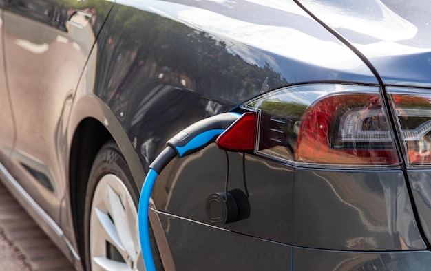 Electric car battery charging at a charge station closeup view