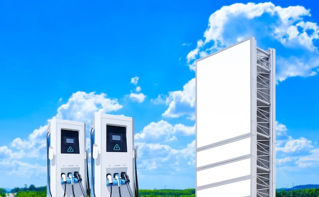 Electric car charging station with blank billboard on blue sky and cloud background clean energy alternative energy EV car and charging station technology concept