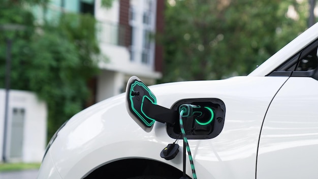 Electric car plugged in with home charging station Peruse