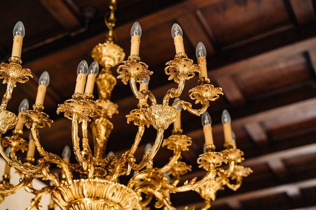 Electric chandelier with bulbs antique golden chandelier in the interior of an old villa