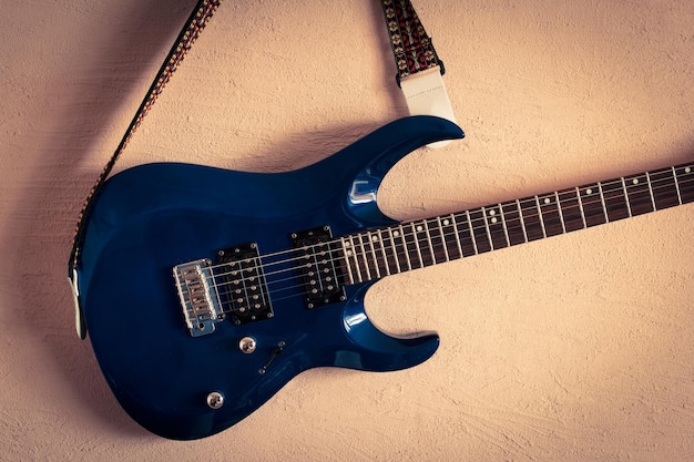 Electric guitar on a background of vintage beige wall