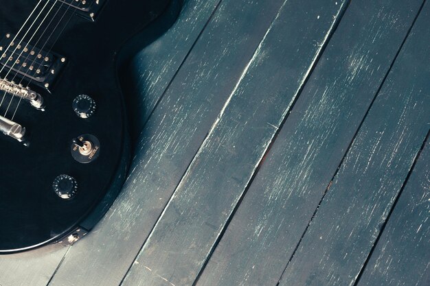 木製の背景にエレキギターのボディとネックの詳細