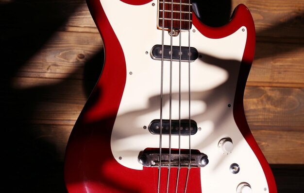 Electric guitar with shadow hand on wooden background