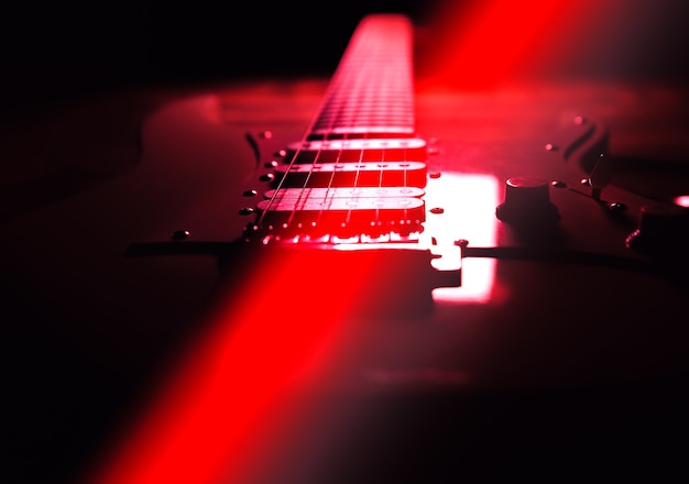 Electric guitar on wooden background. retro music concept. red\
shadows.