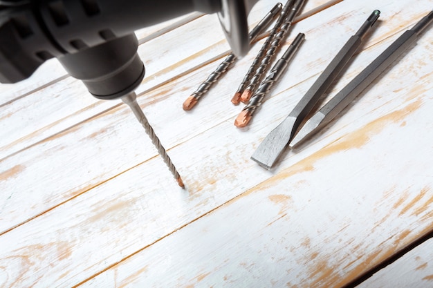 Electric hammer drill lies on a wooden table