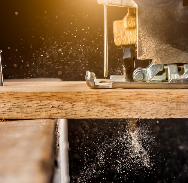 Photo electric jigsaw cutting a piece of wood