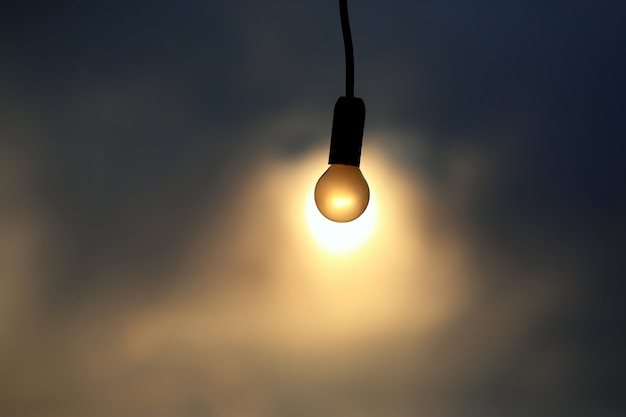 Фото Электрическая лампа на фоне заката