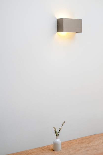 Photo electric lamp on table against white wall at home